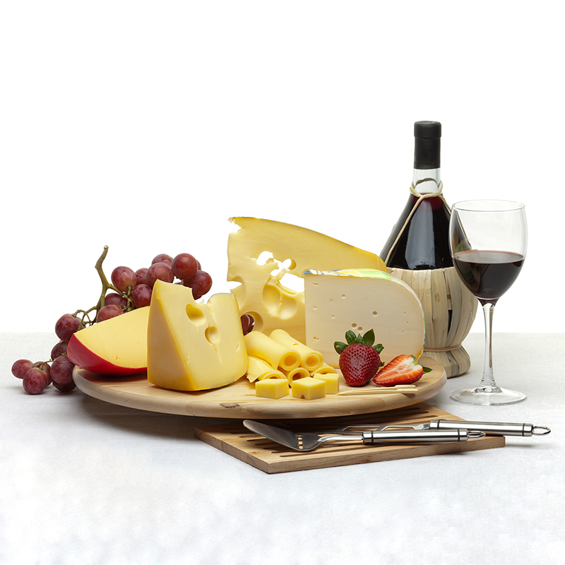 Composition of cheese, grapes, bottles and glasses of wine and strawberries on a wooden round tray on a white tablecloth, isolated on a white background